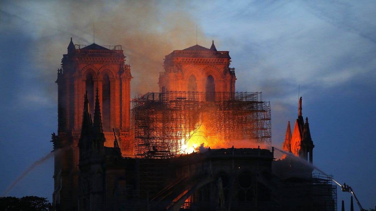 Ein Feuerwehrmann (r) versucht, das Feuer in der Kathedrale Notre-Dame zu löschen.