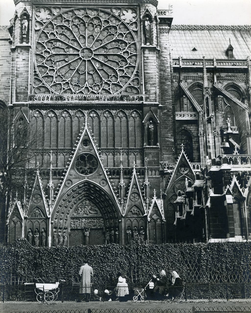Südliches Querschiff, 1968: Mit 32 Metern sind die Querschiffe der Kirche deutlich höher als die Seitenschiffe. An diesem Teil von Notre-Dame ist klar die gotische Prägung der Kathedrale zu sehen. Zahlreiche christliche Figuren sind neben den Türen des Querschiffs zu sehen. Zudem sind über den Türbogen biblische Szenen dargestellt.