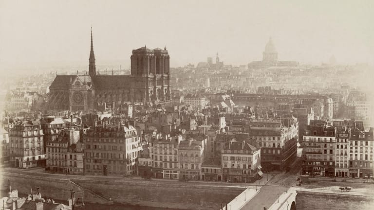 Notre-Dame ca. 1865: Die Kathedrale erhebt sich über die Häuser von Paris. Von 1163 bis 1345 erbaut, gab es immer wieder Erneuerungen der Kirche. Im Jahr 1858 wurden in der erzbischöflichen Grabkammer im Rahmen einer Restaurierung historische Gräber freigelegt.