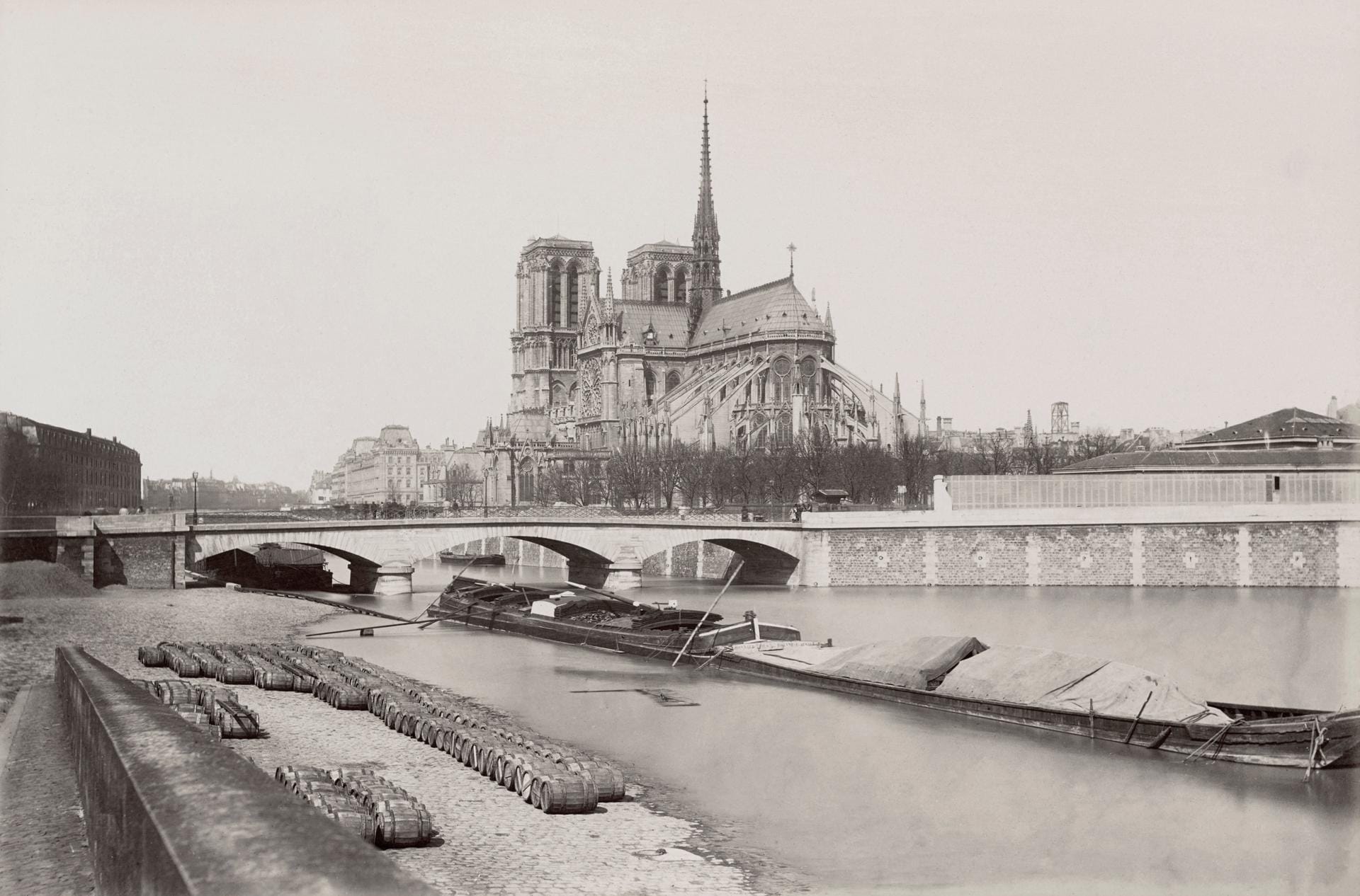 Foto der Kathedrale um 1876: Von den Ufern der Seine aus war die weltberühmte Kirche immer gut zu sehen. Die markanten Streben auf der Südseite des Gebäudes waren 1180/1200 eine architektonische Neuigkeit. Durch das Strebewerk konnte das Gewicht der Kirche abgefangen werden.