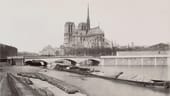 Foto der Kathedrale um 1876: Von den Ufern der Seine aus war die weltberühmte Kirche immer gut zu sehen. Die markanten Streben auf der Südseite des Gebäudes waren 1180/1200 eine architektonische Neuigkeit. Durch das Strebewerk konnte das Gewicht der Kirche abgefangen werden.