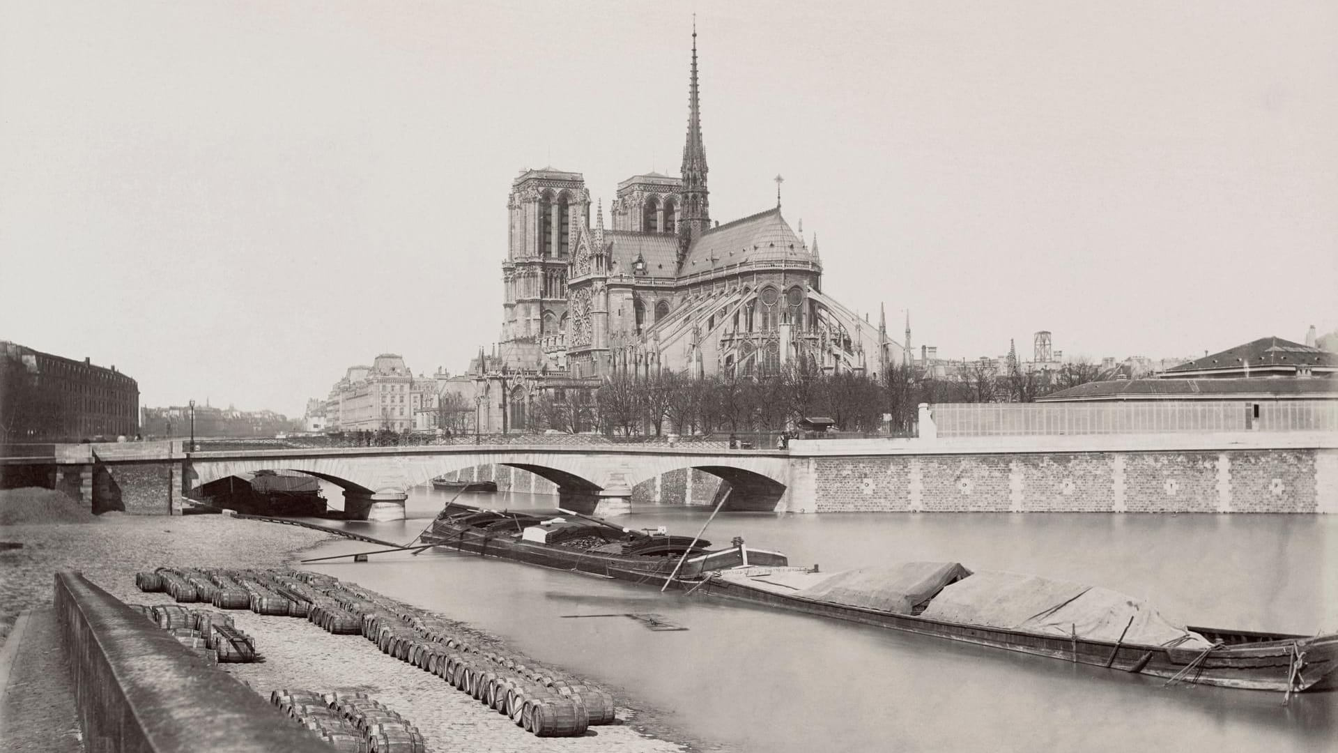 Foto der Kathedrale um 1876: Von den Ufern der Seine aus war die weltberühmte Kirche immer gut zu sehen. Die markanten Streben auf der Südseite des Gebäudes waren 1180/1200 eine architektonische Neuigkeit. Durch das Strebewerk konnte das Gewicht der Kirche abgefangen werden.