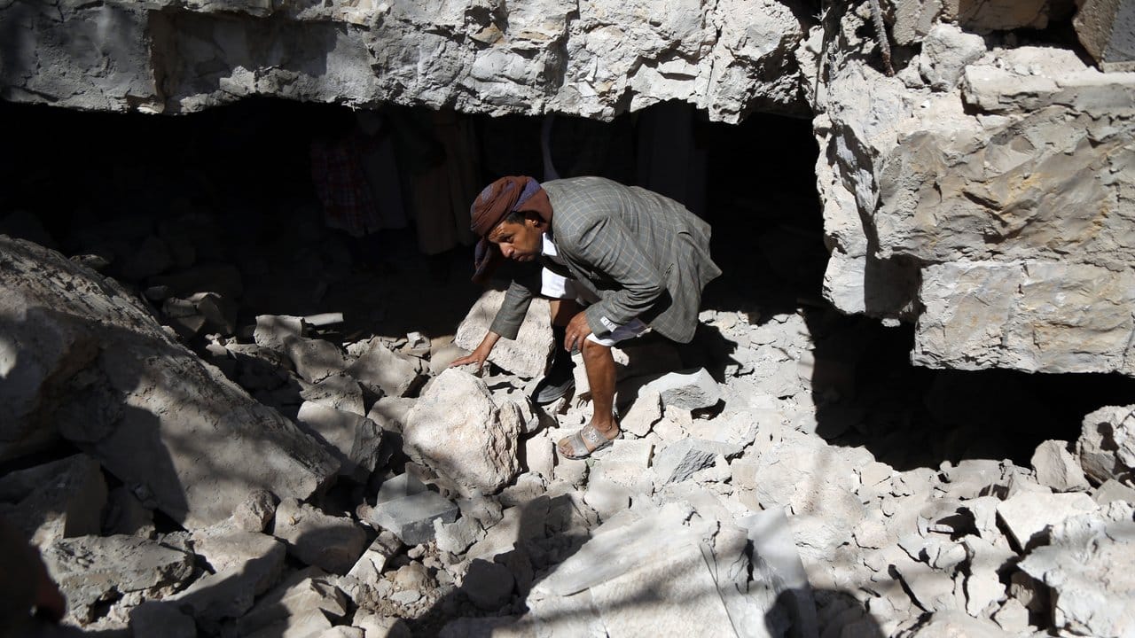 Ein Mann inspiziert die Trümmer eines Hauses, das bei einem Luftangriff zerstört wurde.