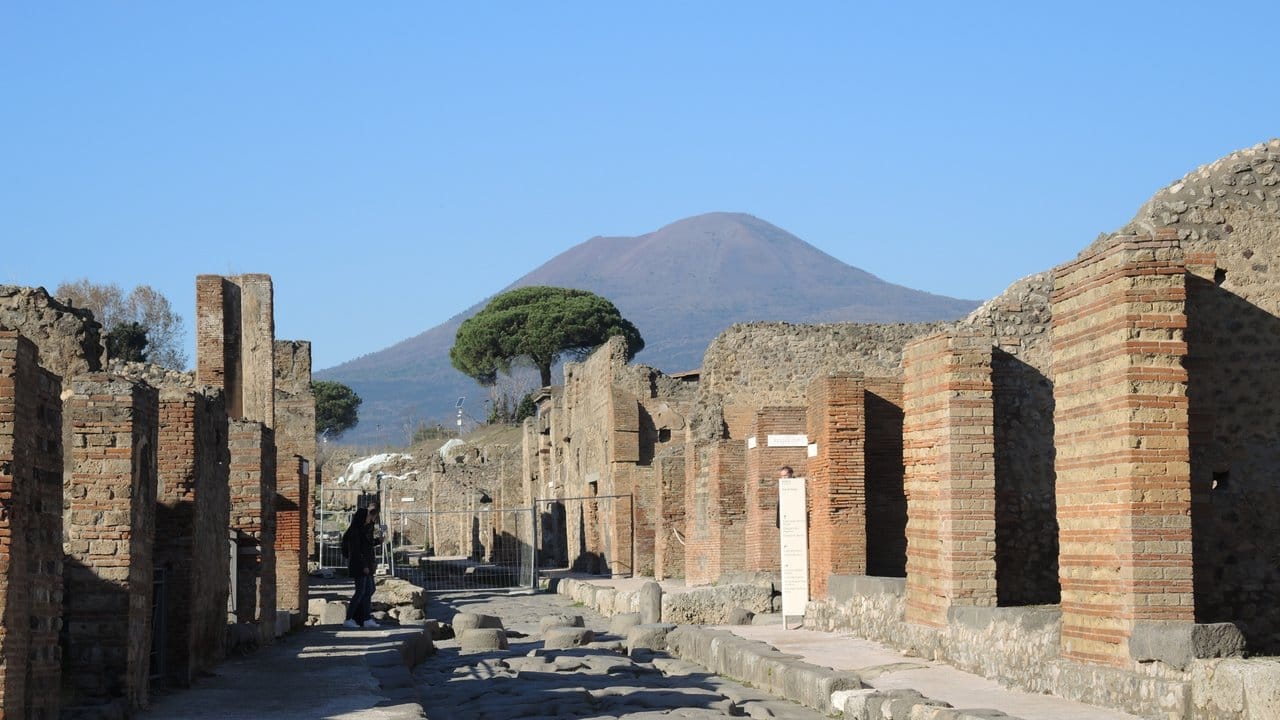 Eine Straße im Archäologischen Park Pompeji mit Blick auf den Vesuv.
