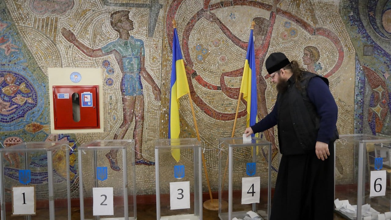 Ein orthodoxer Priester gibt seine Stimme bei der Stichwahl um das Präsidentenamt in einem Wahllokal ab.