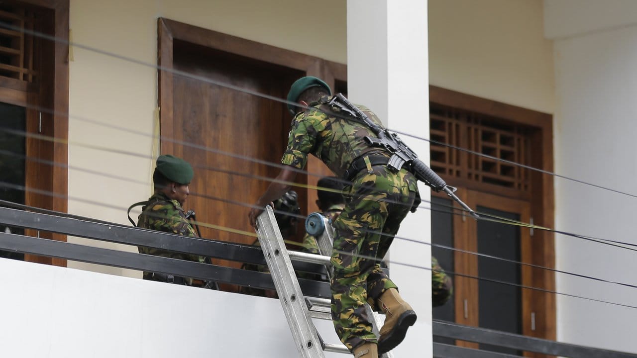 Ein sri-lankisches Polizeikommando betritt über eine Leiter ein Haus, das nach einem Schuss in Colombo als Versteck von Militanten vermutet wird.