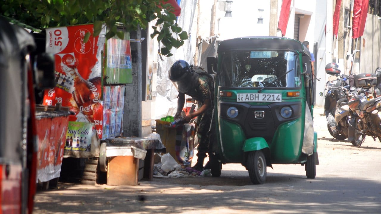 Ein Polizist überprüft am Straßenrand stehende Objekte in der Hauptstadt von Sri Lanka.