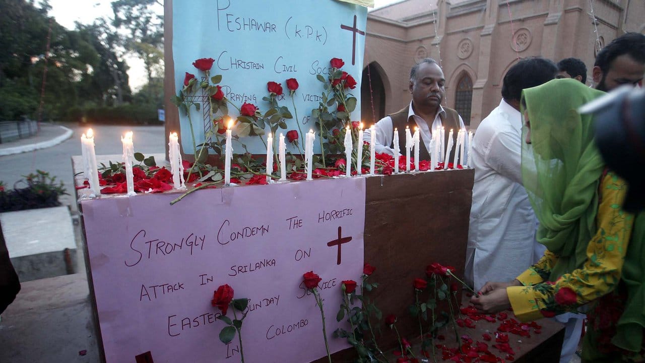 Um Mitgefühl und Trauer für die Opfer zu zeigen, zünden Mitglieder einer christlichen Gemeinschaft Kerzen in der St.