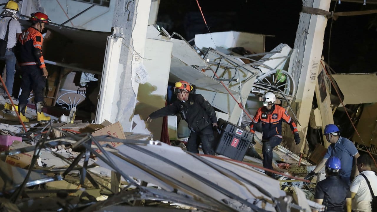 Rettungskräfte suchen in einem eingestürzten Gebäude nach Überlebenden. Rettungskräfte suchen in einem eingestürzten Gebäude nach Überlebenden.