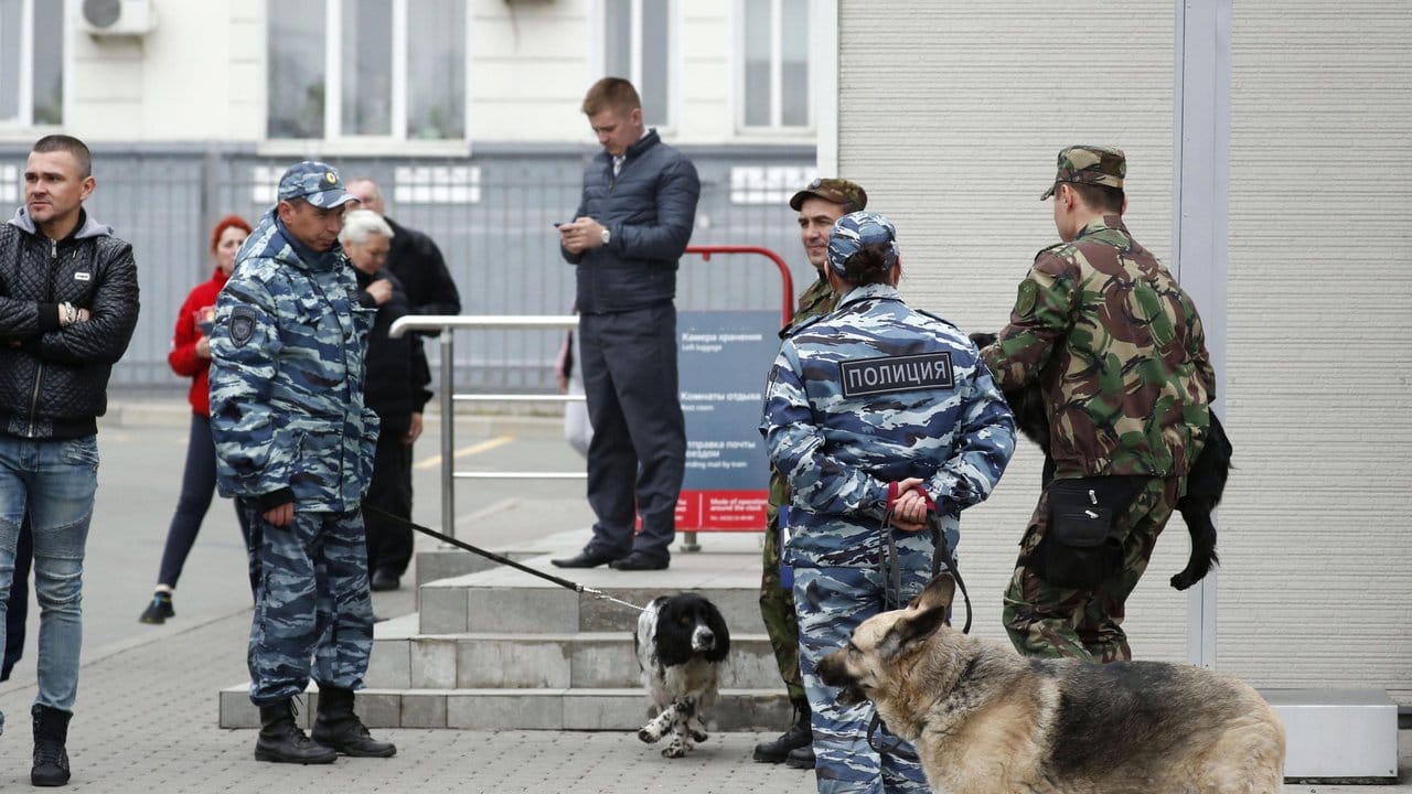 Polizisten mit Spürhunden patrouillieren in der Nähe des Bahnhofs Wladiwostok.