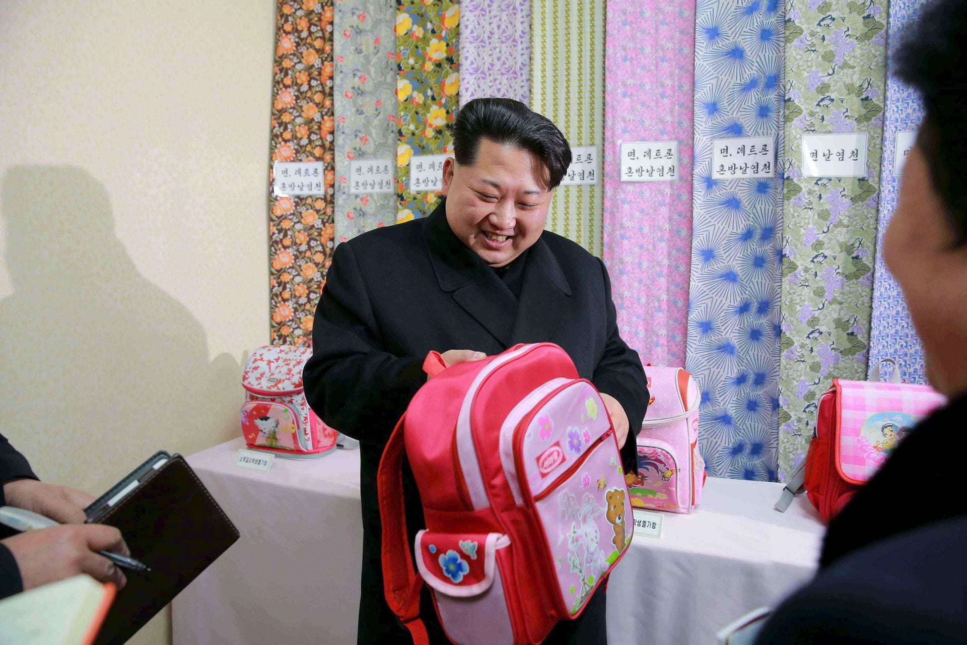 Nach Lebensmitteln, Schmiermittel und Seife ist eine Textilfabrik dran. Kim bewundert hier einen pinken Rucksack für Kinder.