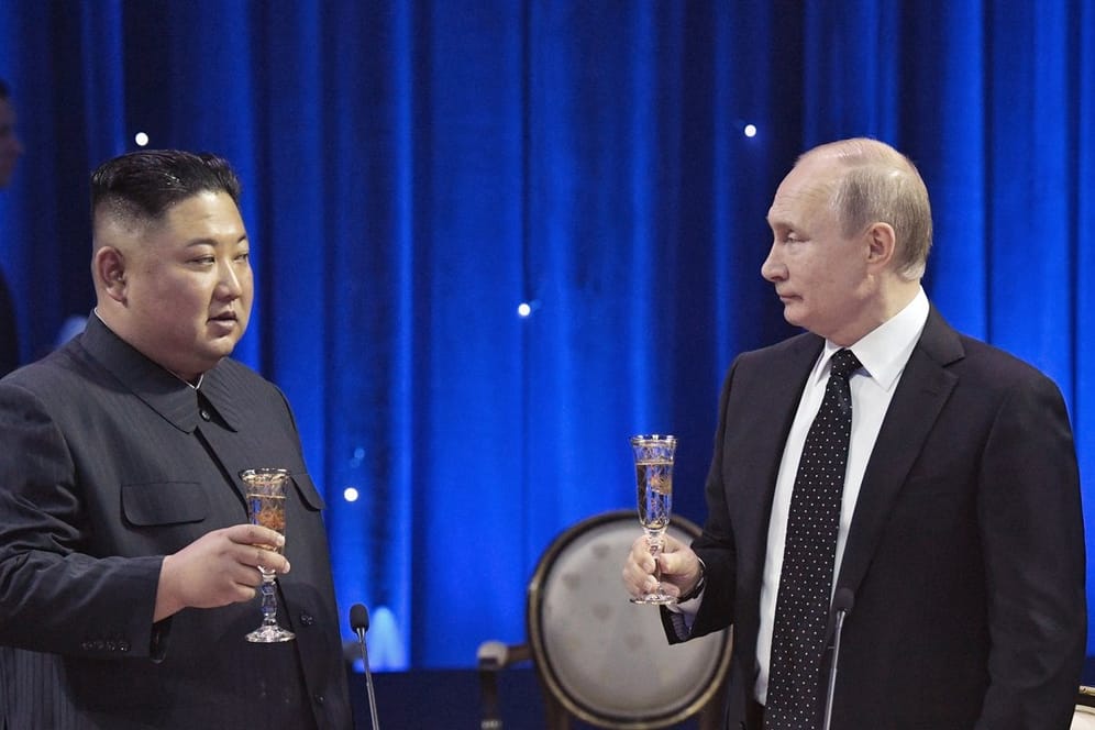 Kim Jong Un und Wladimir Putin stoßen nach ihrem Gespräch miteinander an.