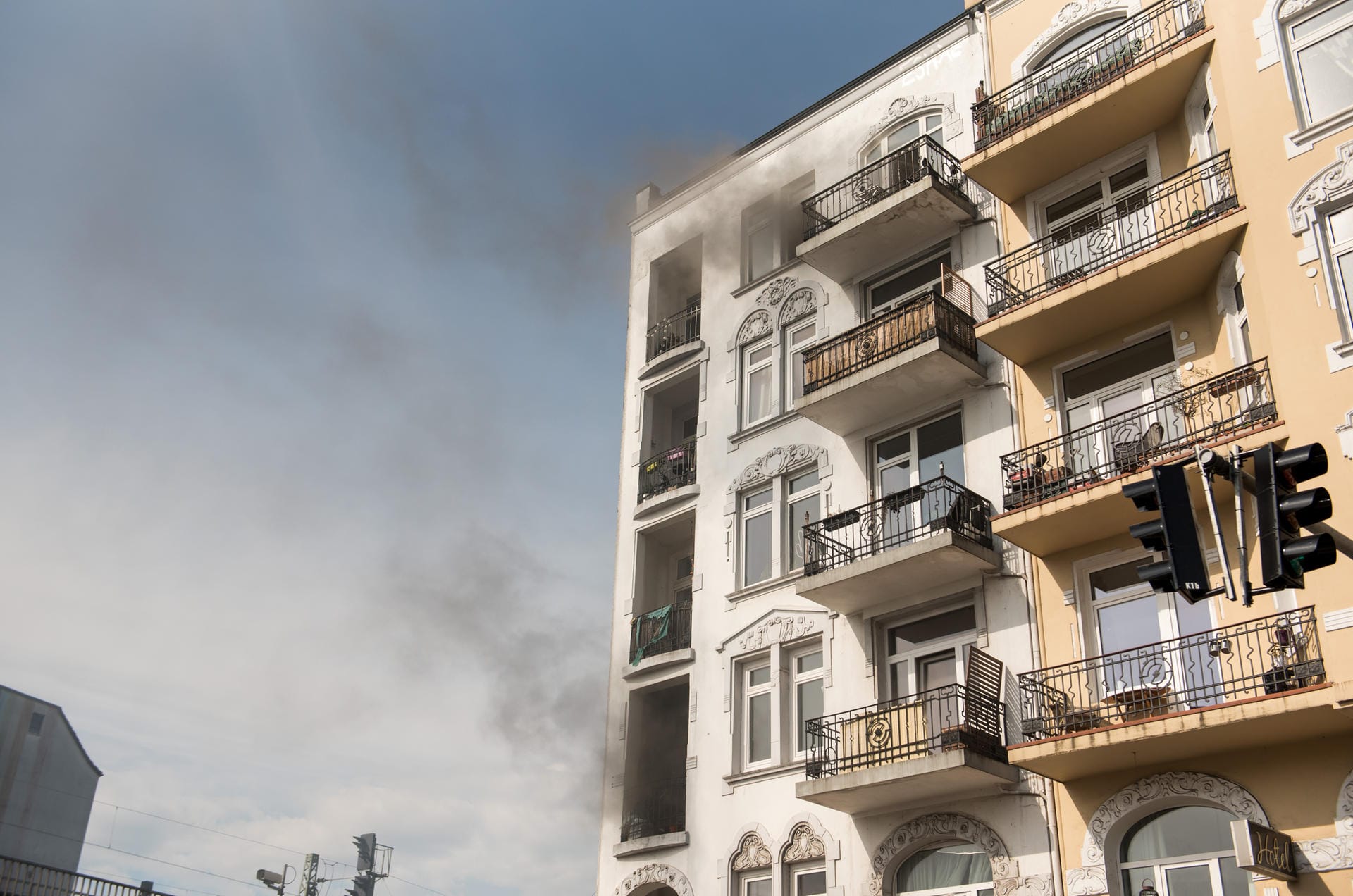 Rauch dringt aus dem Haus im Schanzenviertel: Weil der Weg auf die Straße durch Qualm versperrt war, flüchteten mehrere Bewohner auf Balkone und das Dach eines Nachbargebäudes.