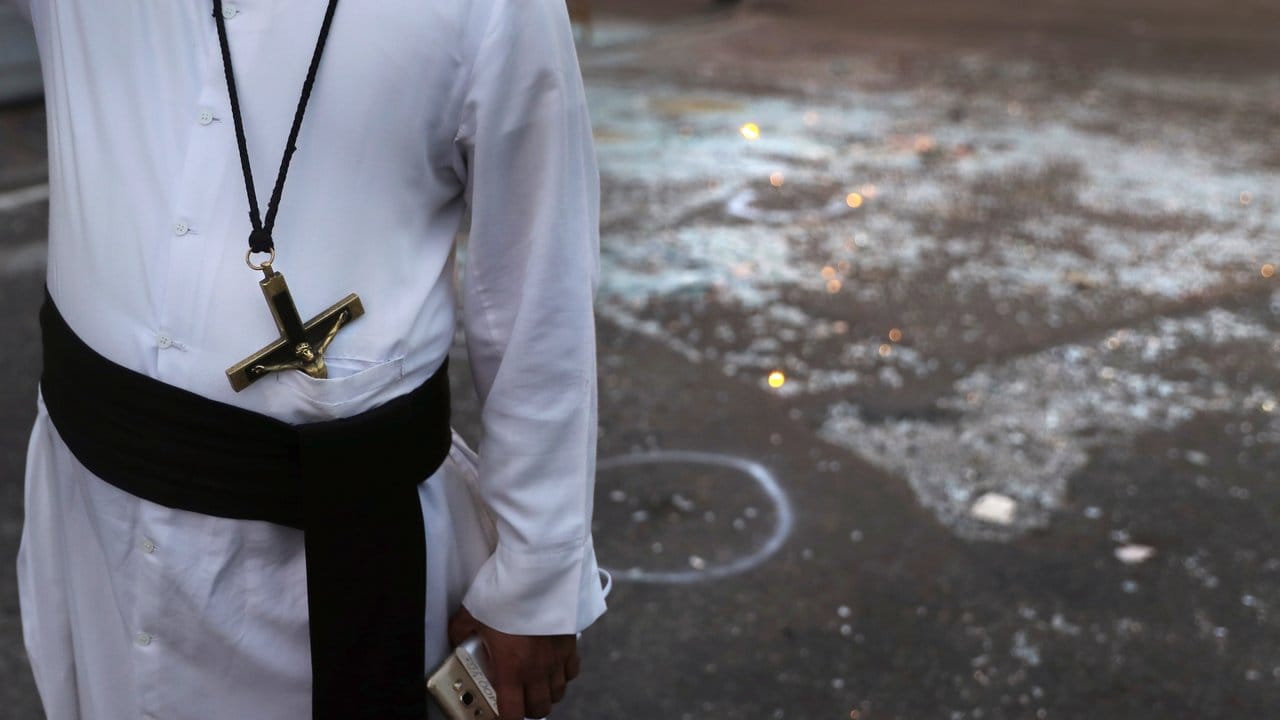 Nach den Anschlägen: Ein katholischer Priester steht neben Glasscherben in Colombo.