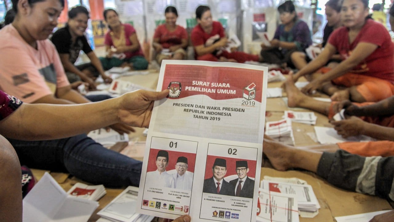 Wahlhelfer falten Stimmzettel, die an Wahlstationen in der Provinz Sumatra Utara verteilt werden.
