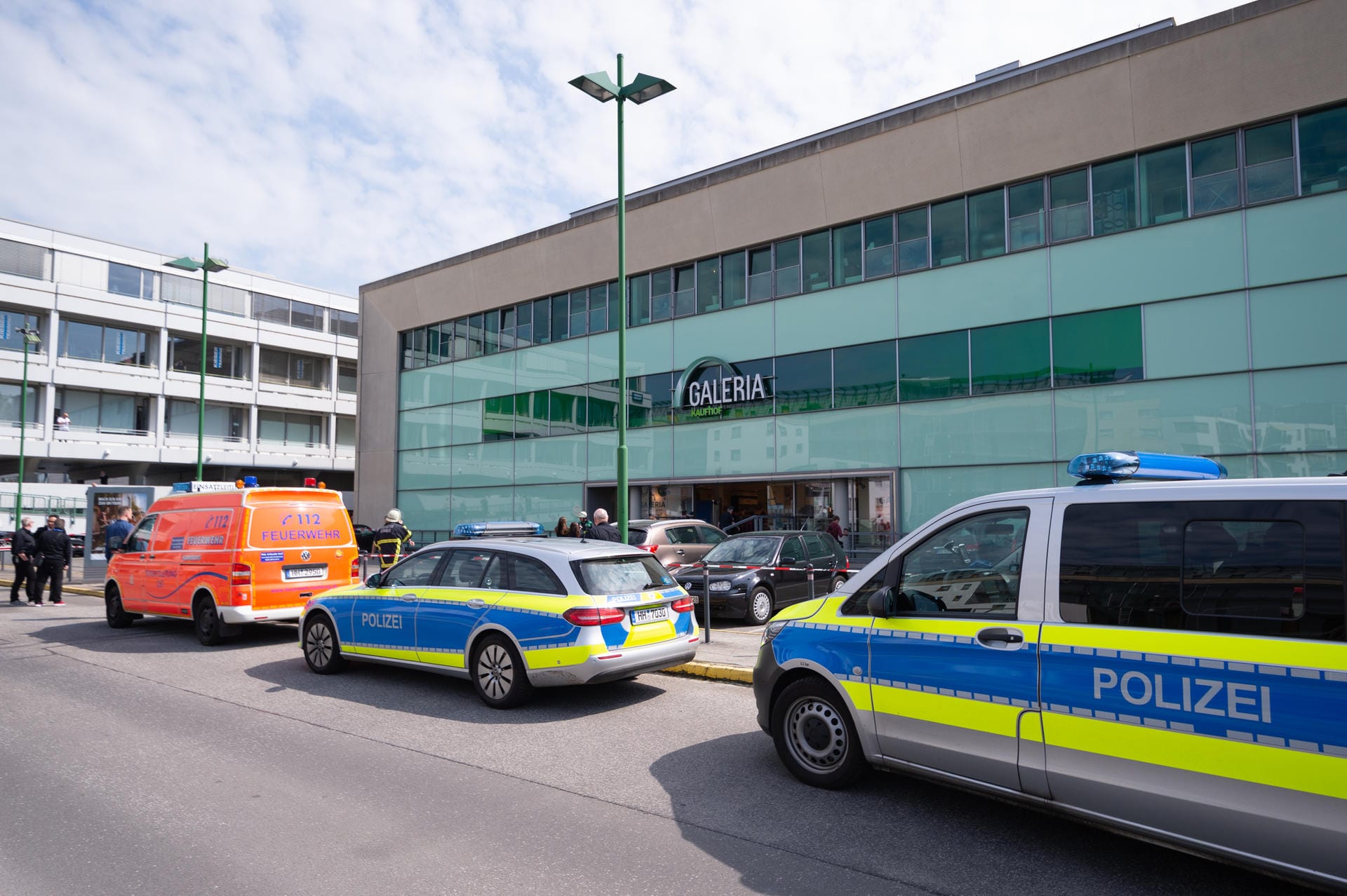 Einsatzfahrzeuge von Feuerwehr und Polizei stehen vor dem Hamburger Einkaufszentrum.