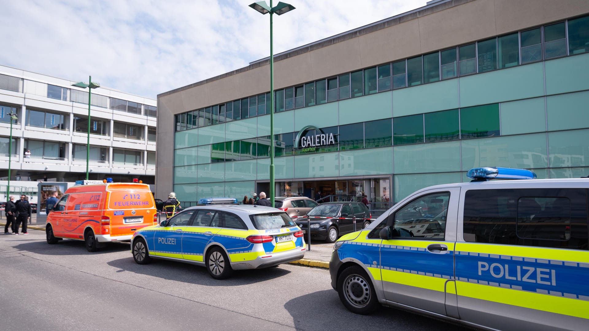 Einsatzfahrzeuge von Feuerwehr und Polizei stehen vor dem Hamburger Einkaufszentrum.