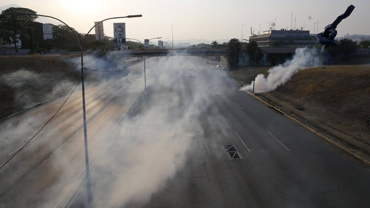 Eine Wolke aus Tränengas liegt über einer leeren Straße nahe dem Luftwaffenstützpunkt La Carlota.