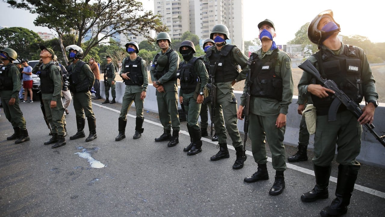 Soldaten stehen vor dem Luftwaffenstützpunkt La Carlotan, nachdem Oppositionsführer López aus dem Hausarrest befreit wurde.