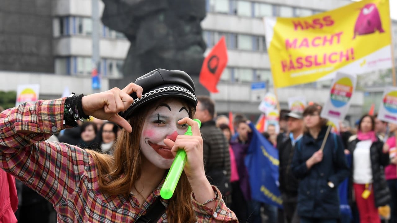 Teilnehmer einer Demonstration unter dem Motto "Aufstehen gegen Rassismus", darunter auch diese als Clown geschminkte Frau, haben sich am 1.