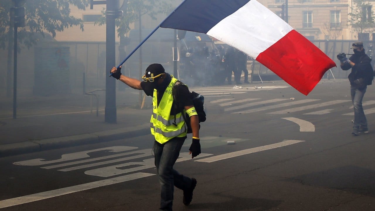 Ein Demonstrant schwenkt in Paris eine französische Flagge.