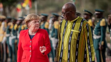 Bundeskanzlerin Angela Merkel wird mit militärischen Ehren von Burkina Fasos Staatschef Roch Marc Kaboré am Präsidentenpalast begrüßt.