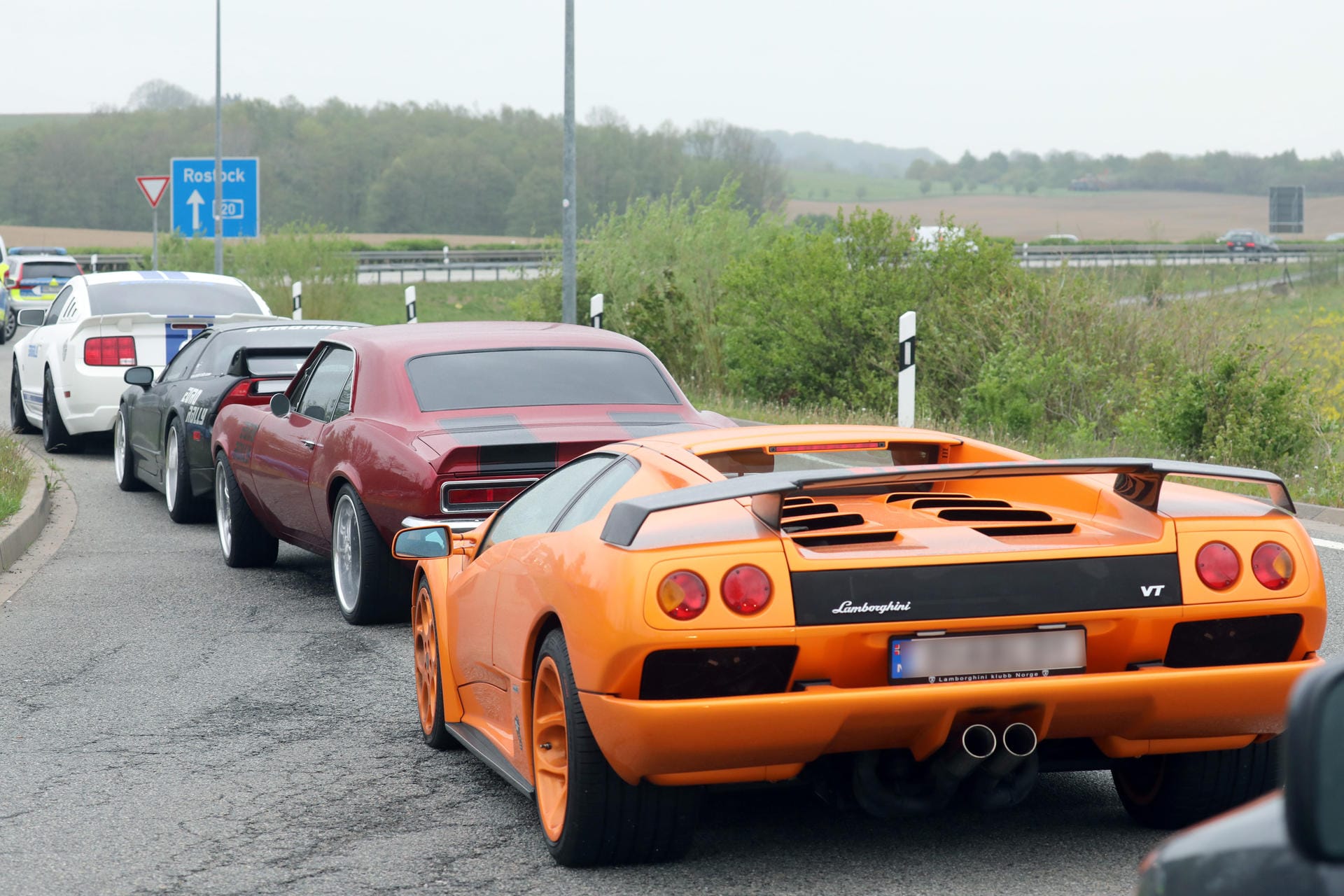 Ein Lamborghini und andere Sportwägen stehen in einer Reihe: Viele der Autos tragen norwegische Kennzeichen.