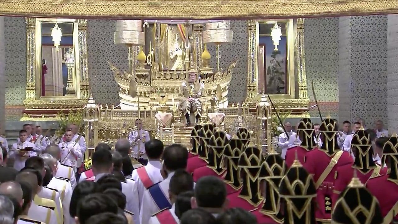 Thailands König Maha Vajiralongkorn sitzt nach seiner Krönung auf dem Thron vor Diplomaten und Würdenträgern.