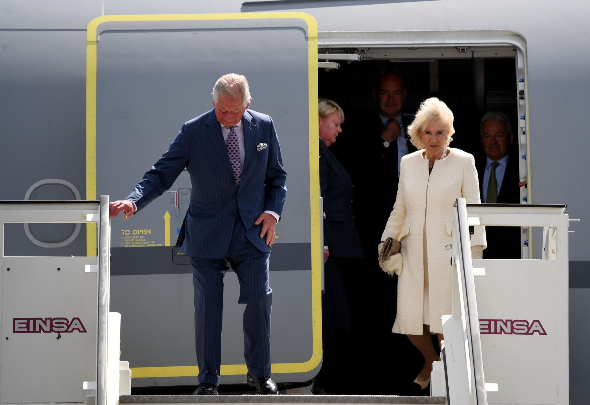 Prinz Charles und Camilla verlassen das Flugzeug.