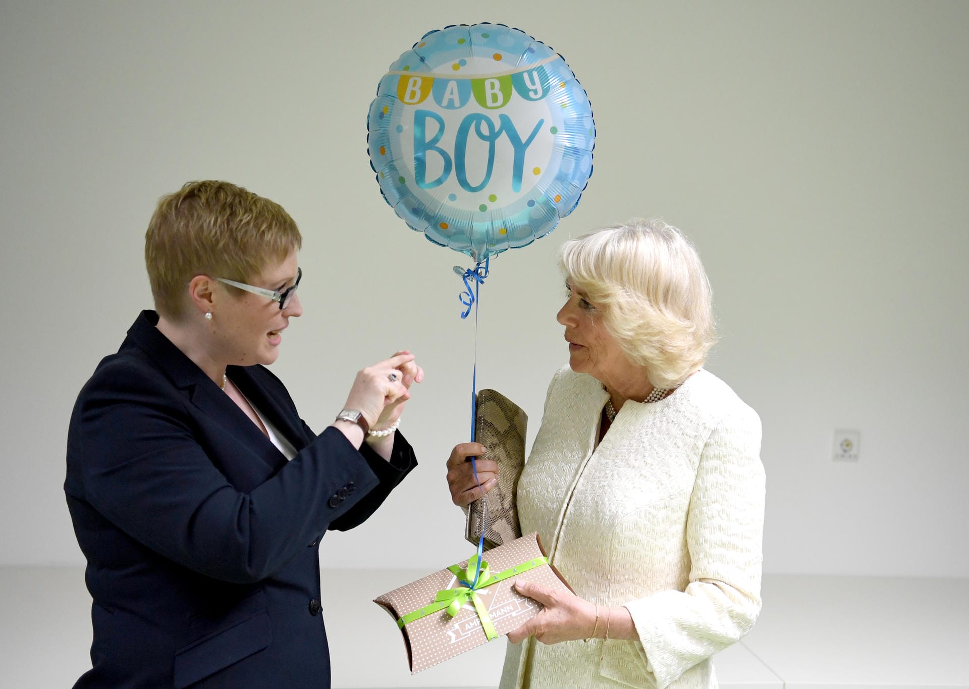 Camilla erhält bei einem Besuch der Gewaltschutzambulanz in der Charite ein Geschenk und einen Luftballon für ihr am Vortag geborenes Enkelkind.