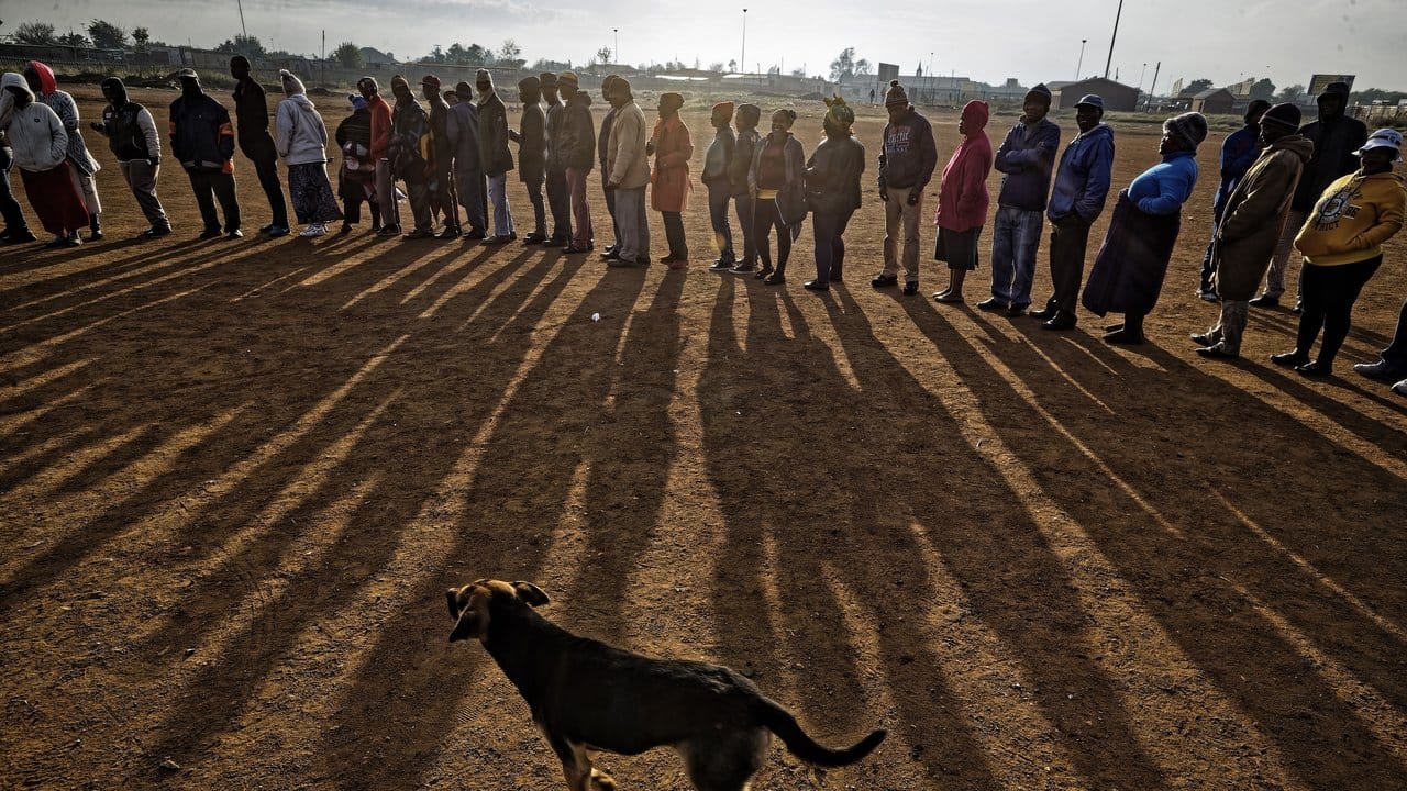 Menschen stehen am frühen Morgen Schlange, um ihre Stimme in der Bergbauregion Bekkersdal abzugeben.