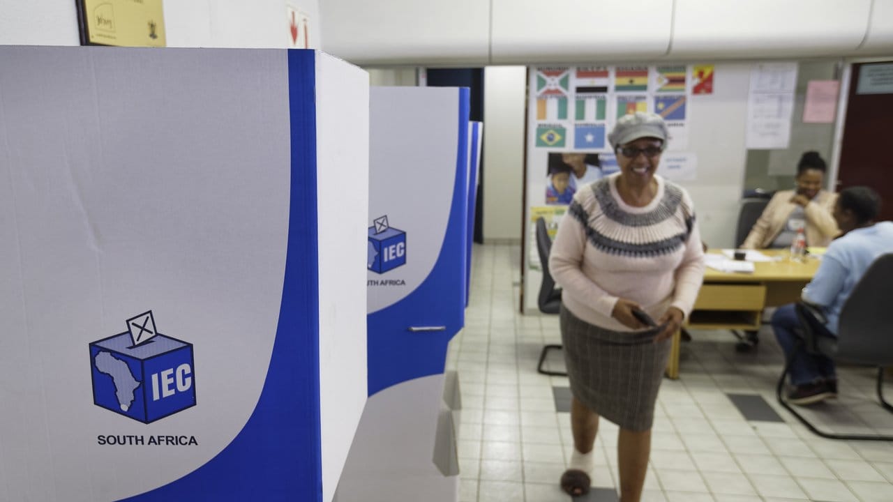 Eine Wahlhelferin geht in Johannesburg an Wahlkabinen vorbei.