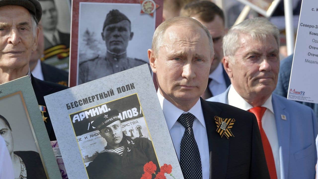 Wladimir Putin hält ein Porträt seines Vaters Wladimir Spiridonowitsch Putin.