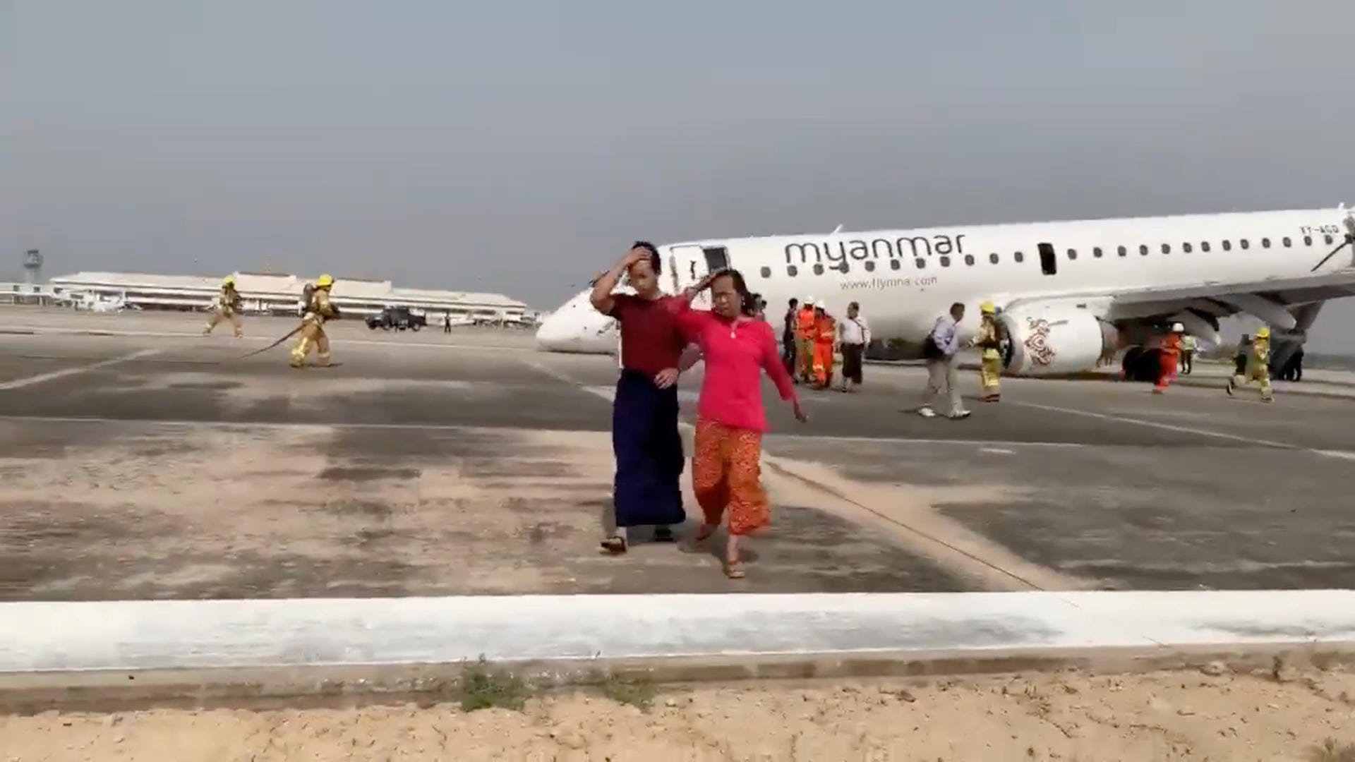 Passagiere verlassen das Gebiet um das Flugzeug: Rettungskräfte helfen den Menschen dabei, das Flugzeug zu verlassen.