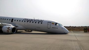 Die Maschine der Myanmar National Airline, nachdem sie ohne Vorderräder zum Stehen gekommen ist: Rettungskräfte können sich nun dem Flugzeug annähern.