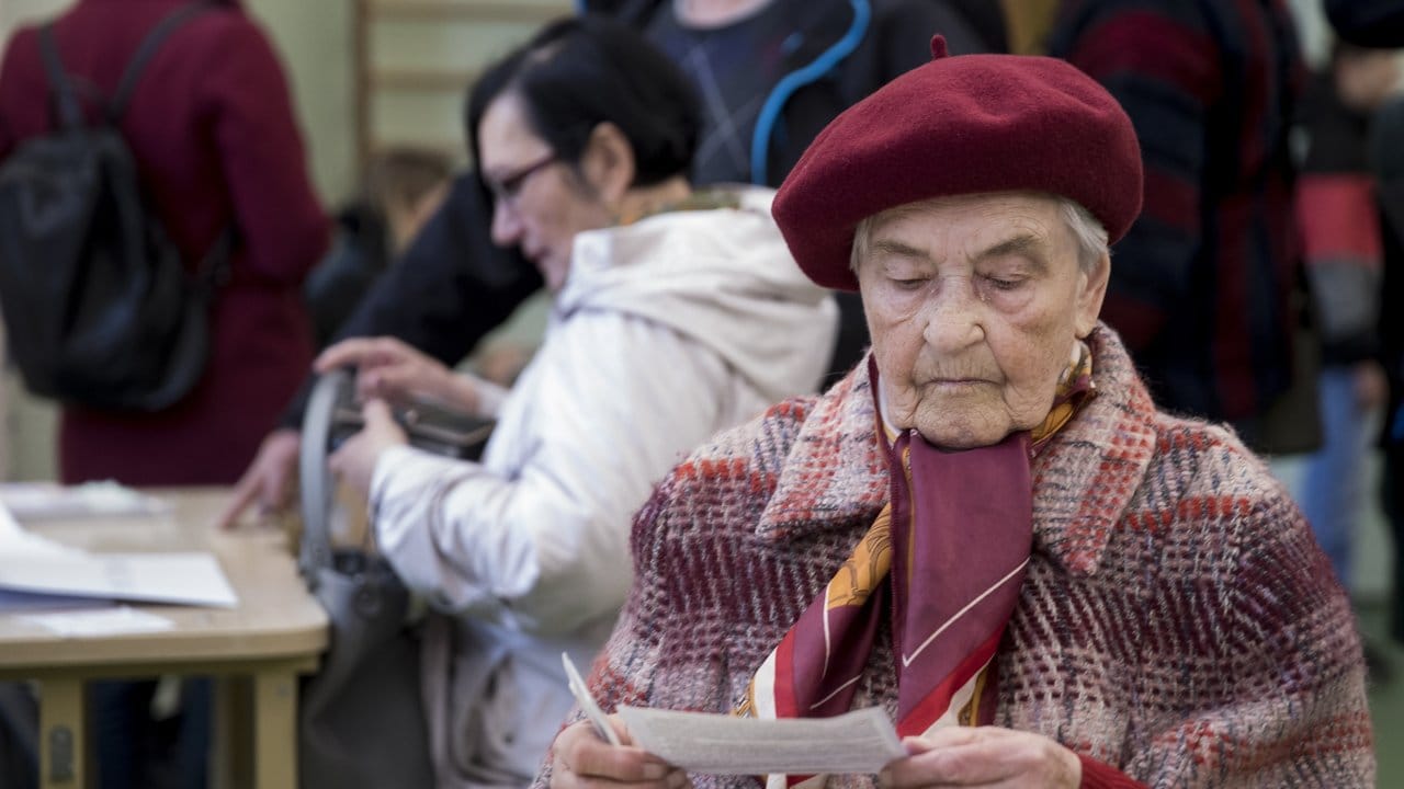 Eine Frau liest den Stimmzettel in einem Wahllokal in Vilnius.