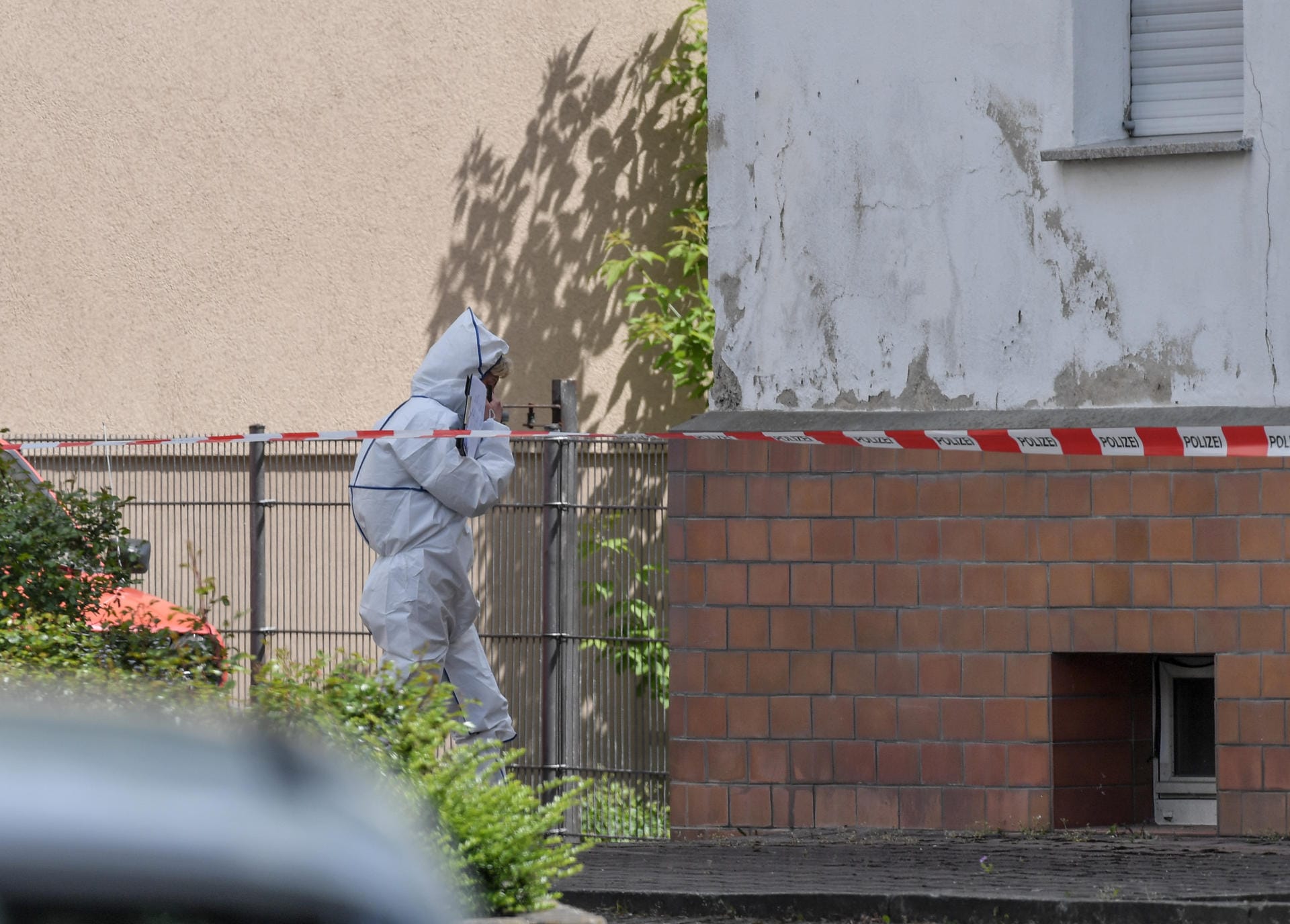Eine Kriminaltechnikerin geht in das abgesperrte Haus in der Amtstraße: Spuren werden gesichert. Noch sind viele Fragen offen.