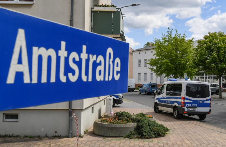 In der Amtstraße im brandenburgischen Forst steht ein Fahrzeug der Polizei: Zwei Männerleichen sind in einer Wohnung in der südbrandenburgischen Kleinstadt im Spree-Neiße-Kreis entdeckt worden.