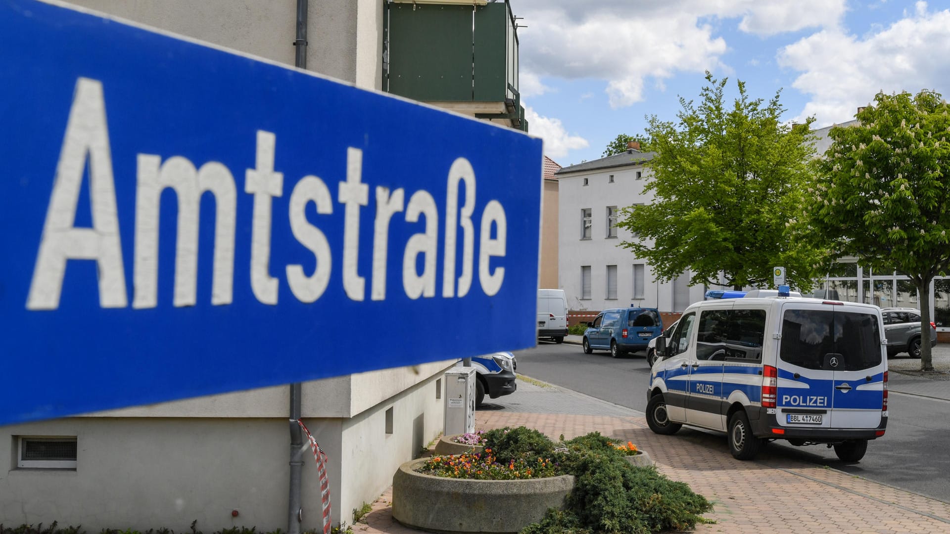 In der Amtstraße im brandenburgischen Forst steht ein Fahrzeug der Polizei: Zwei Männerleichen sind in einer Wohnung in der südbrandenburgischen Kleinstadt im Spree-Neiße-Kreis entdeckt worden.