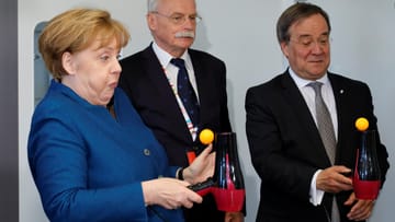 Bundeskanzlerin Angela Merkel bei einem Experiment mit Tischtennisball und Fön, gemeinsam mit Ernst-Andreas Ziegler und Armin Laschet (r.), dem Ministerpräsidenten von Nordrhein-Westfalen.