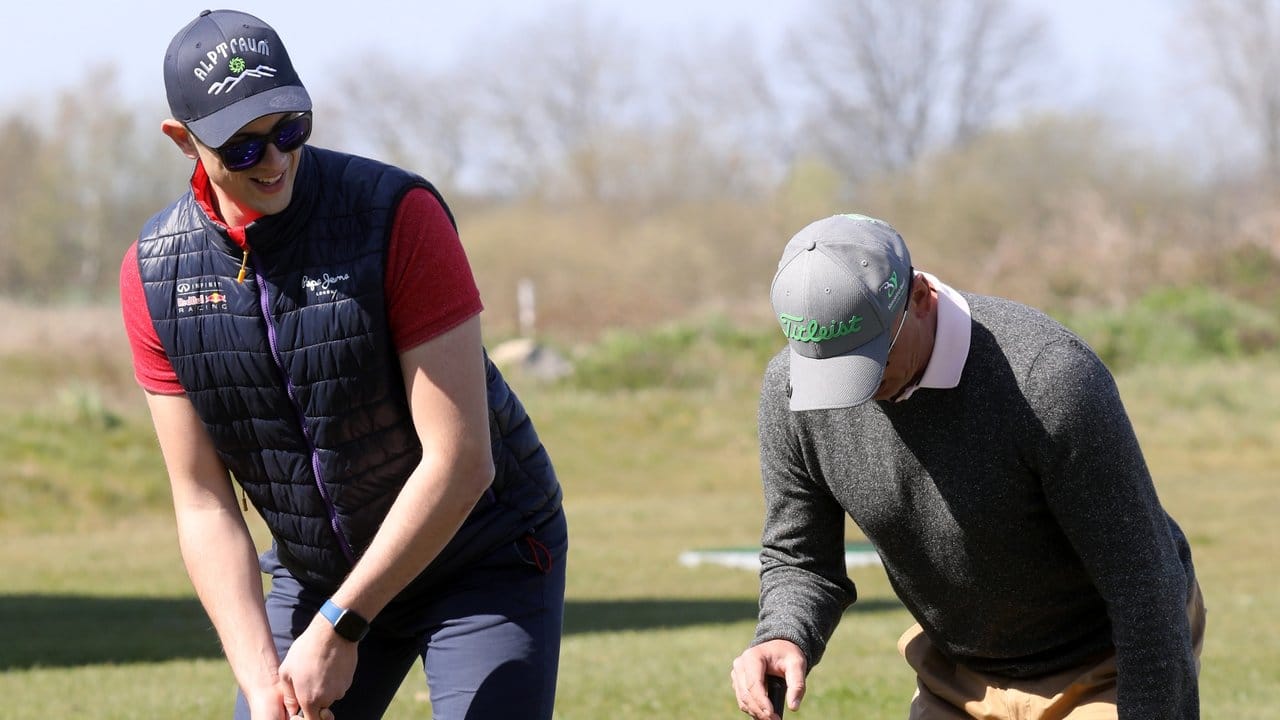 Golflehrer Tom Siegfried (r) uebt mit seinem Schüler Philipp Braun den richtigen Abschlag.