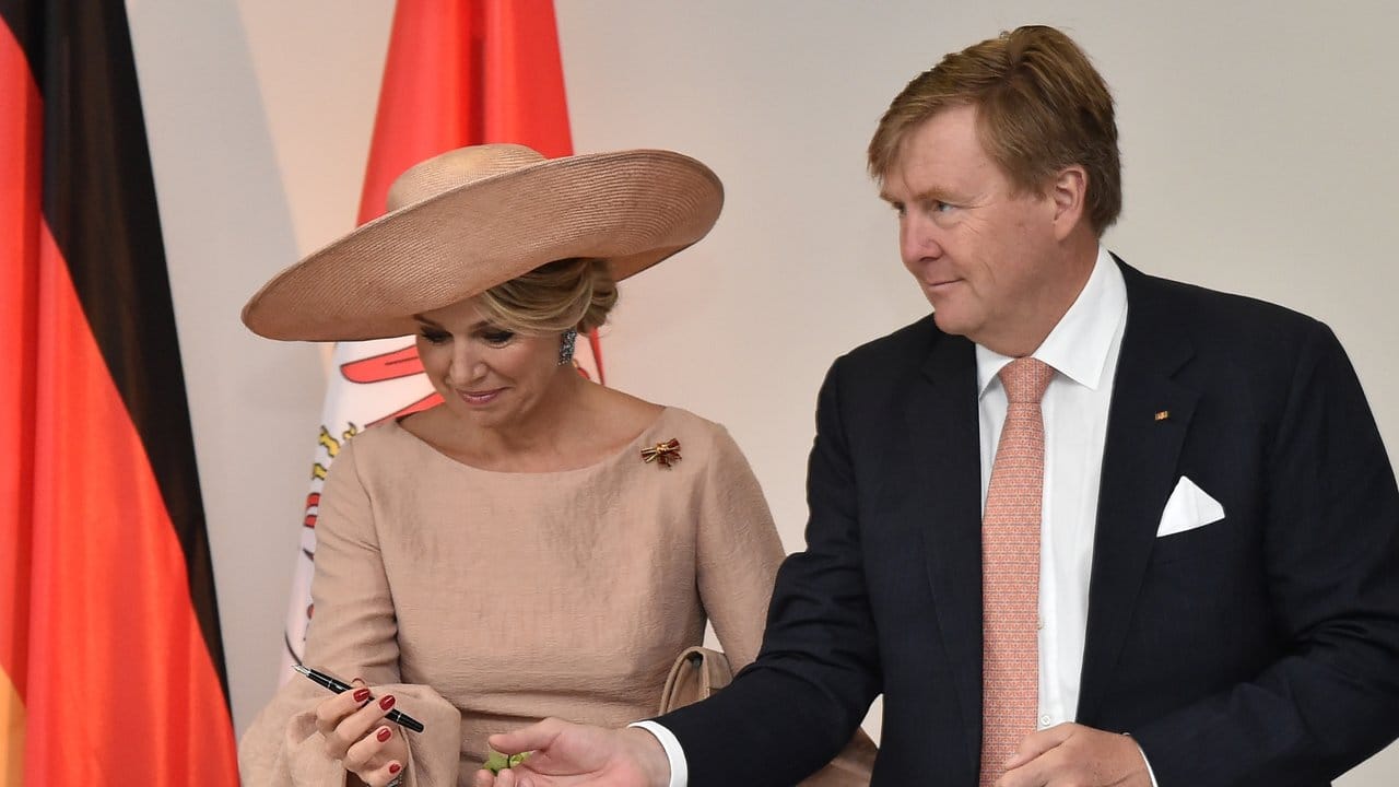 König Willem-Alexander reicht Königin Maxima den Stift für die Eintragung in das Goldene Buch der Staatskanzlei.