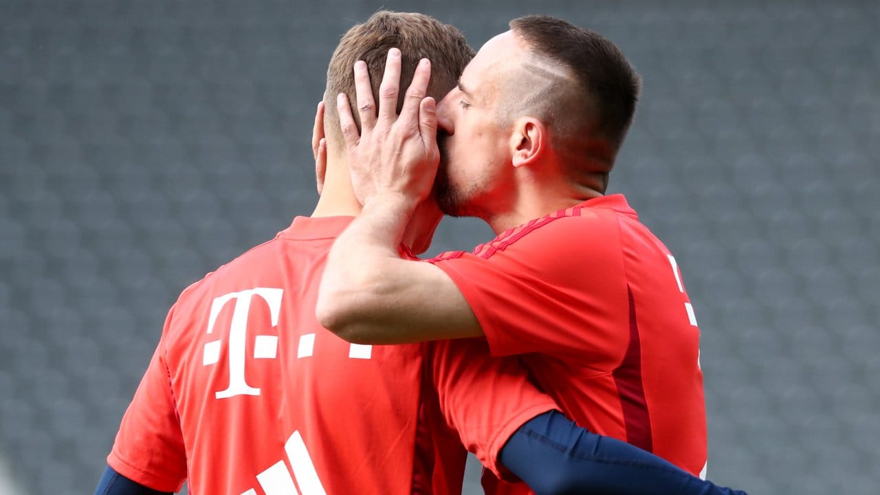 Die Bayern-Stars Joshua Kimmich (l) und Franck Ribéry scherzen beim Abschlusstraining.