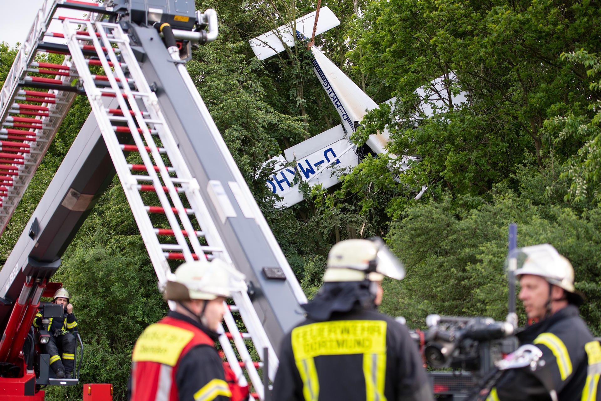 Ein Kleinflugzeug hat sich bei Holzwickede in den Bäumen verfangen. Mitglieder der Feuerwehr Dortmund sind bei der Bergung im Einsatz.
