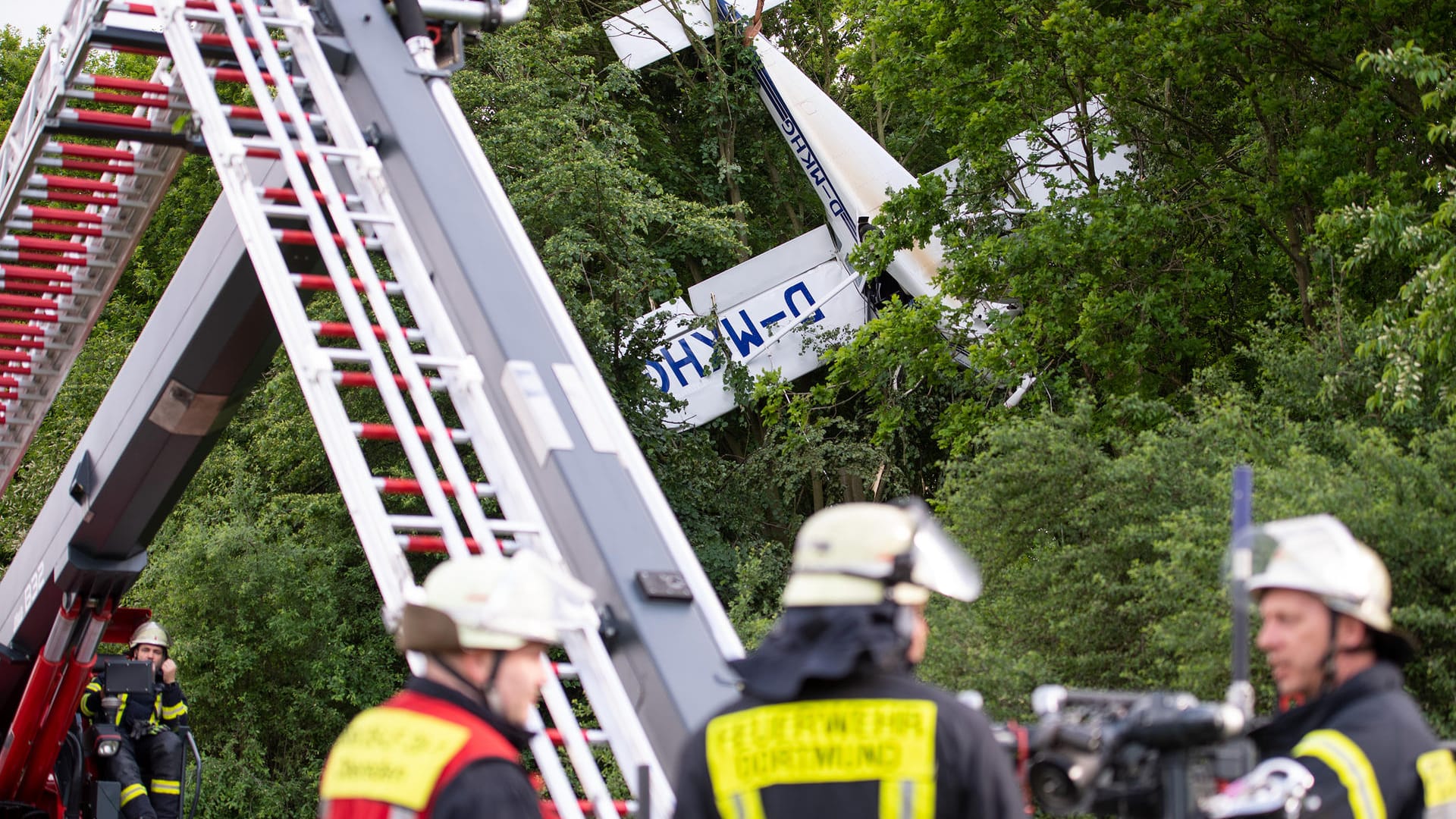 Ein Kleinflugzeug hat sich bei Holzwickede in den Bäumen verfangen. Mitglieder der Feuerwehr Dortmund sind bei der Bergung im Einsatz.