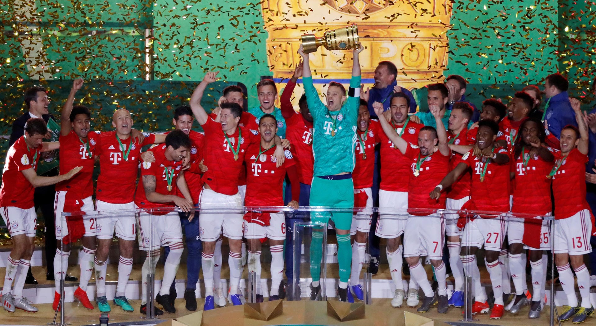 Dann folgt der Moment, auf den alle gewartet haben: Kapitän Manuel Neuer (M.) bekommt den Pokal und reckt ihn in den Berliner Nachthimmel.