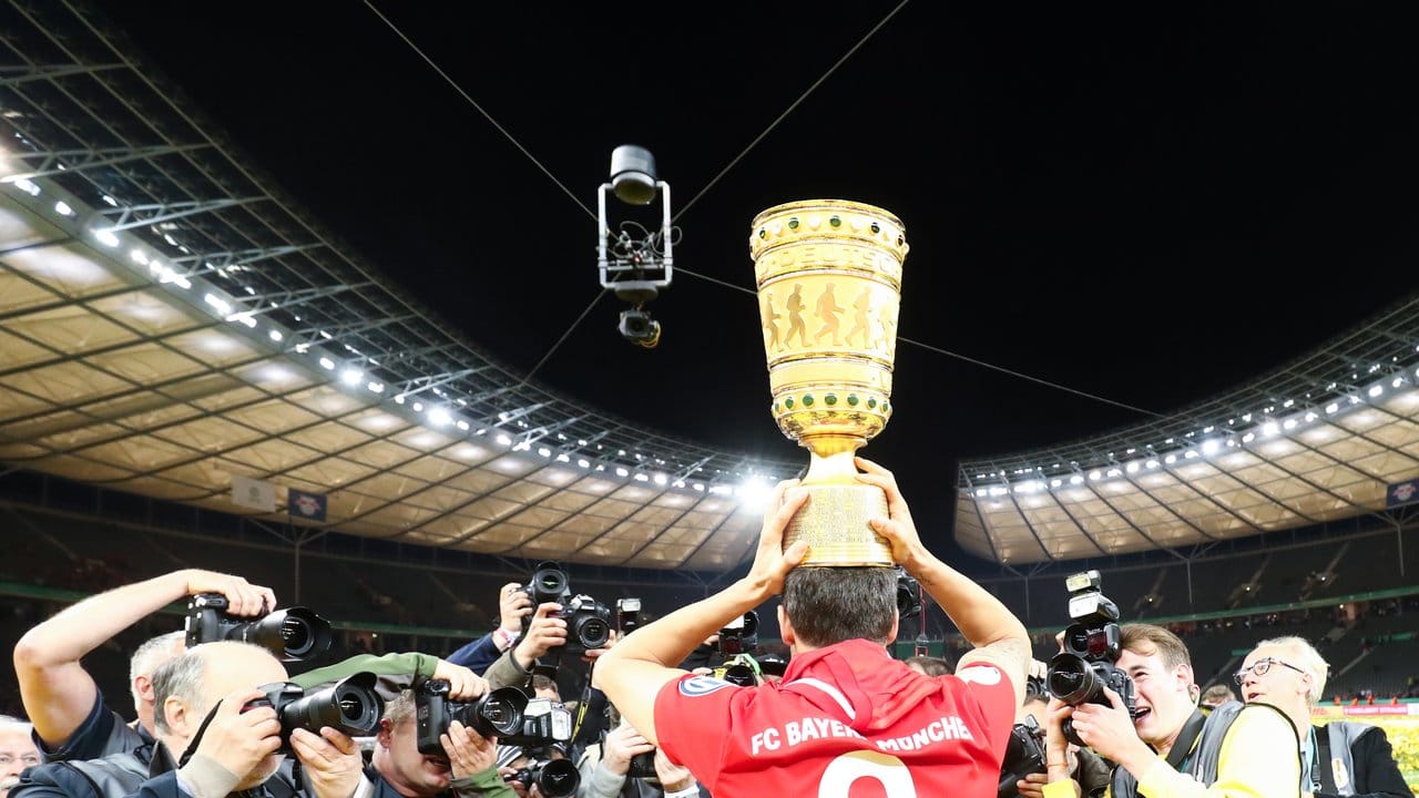 Bayerns Javi Martínez trägt den Pokal auf dem Kopf.