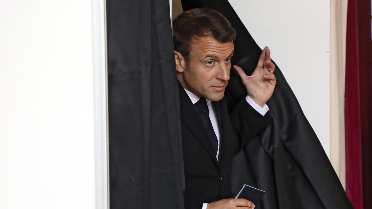 Frankreichs Präsident Emmanuel Macron verlässt nach der Stimmenabgabe eine Wahlkabine in Le Touquet.
