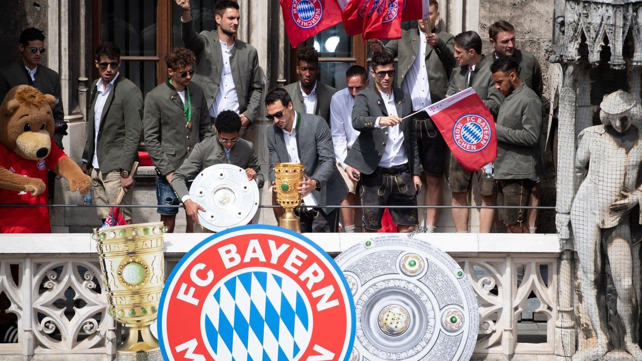 Bayern-Spieler auf dem Balkon des Rathauses am Marienplatz mit der Meisterschale und dem DFB-Pokal.