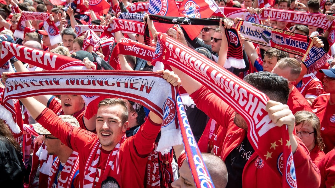 Die Fans des FC Bayern München feiern vor dem Rathaus am Marienplatz das Team.